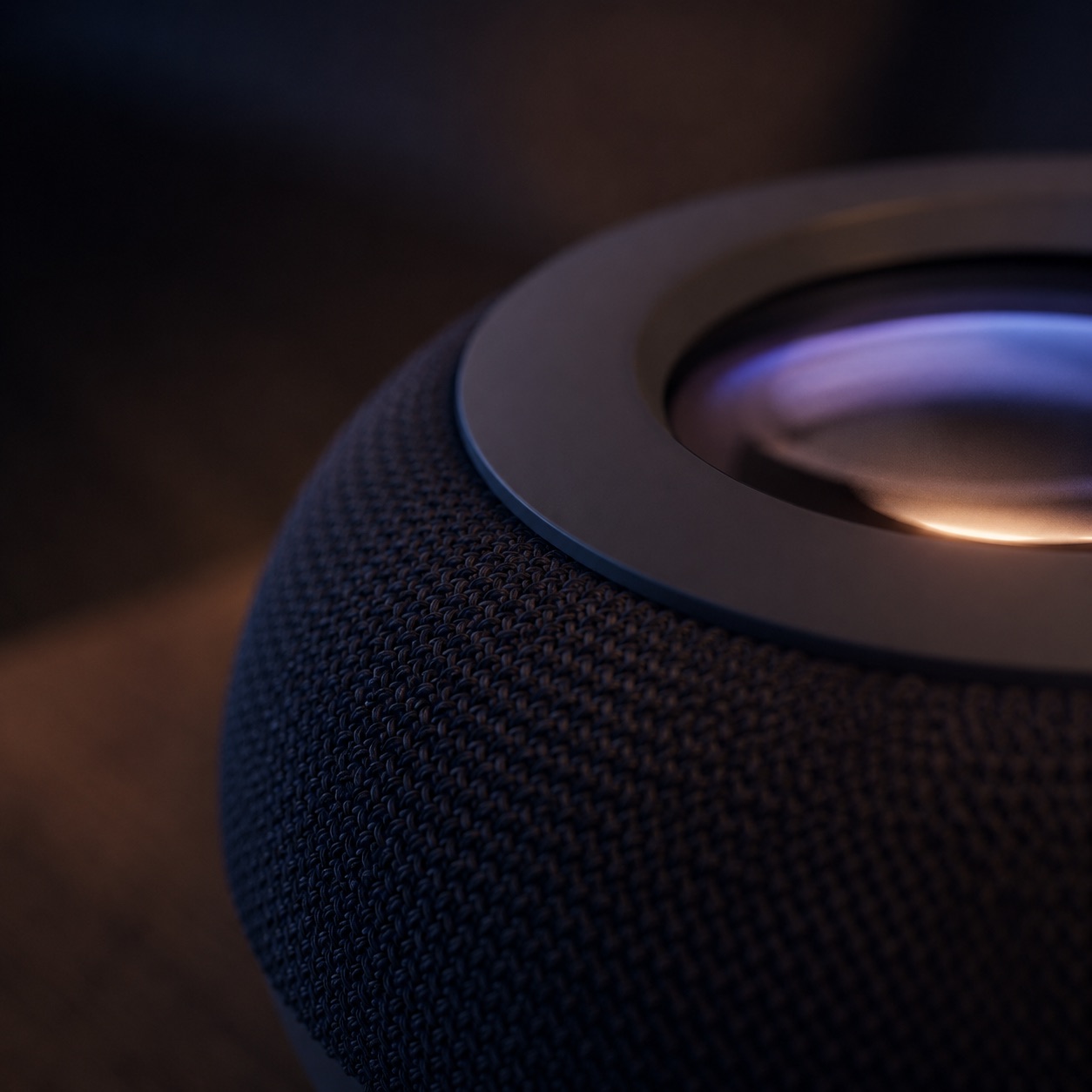 Macro close-up of Neuro's woven acoustic fabric meeting the glass projection lens, warm light glowing within